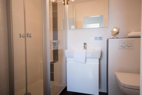 クックスハーフェンにあるFerienwohnung - Frische Brise 04 01のバスルーム(洗面台、トイレ、鏡付)