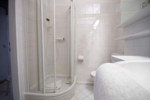 een witte badkamer met een douche en een toilet bij Frische-Brise-10-01 in Cuxhaven