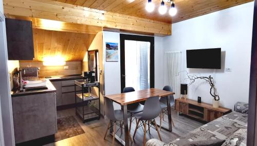 eine Küche und ein Esszimmer mit einem Tisch und Stühlen in der Unterkunft Trilocale mansardato nel cuore della Val Di Fiemme in Ziano di Fiemme