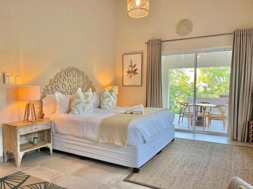 a bedroom with a large bed and a balcony at Bushbaby Valley Lodge in Hazyview