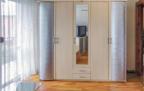 a large white cabinet with a mirror in a room at Stunning Home In Kolczewo With 3 Bedrooms, Sauna And Wifi in Kołczewo