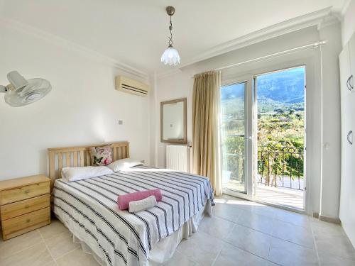 a bedroom with a bed and a large window at 4 Bedroom Deluxe Villa with Mountain and Sea View in Kérynia