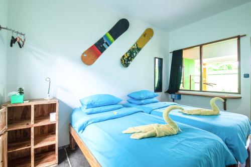 Dos camas en un dormitorio con dos cisnes. en Blue Coco, en Keramas