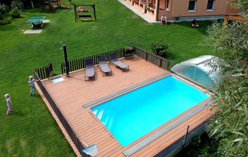 - une vue sur la piscine depuis la terrasse en bois dans l'établissement Apartments Nad Rybníky, à Horní Planá