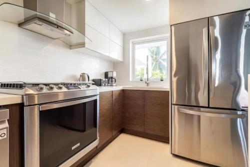 a kitchen with a stainless steel refrigerator and a sink at VILLA CHLOE. Modern 4 rooms house with pool in Cancún