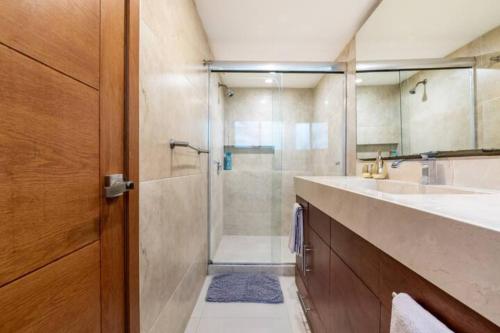 a bathroom with a glass shower and a sink at VILLA CHLOE. Modern 4 rooms house with pool in Cancún