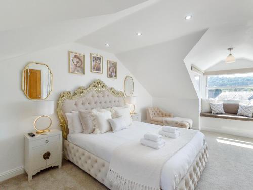 biała sypialnia z dużym łóżkiem i oknem w obiekcie Queen Elizabeth Suite w mieście Stanhope