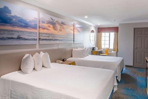a hotel room with two beds and a painting on the wall at Days Inn by Wyndham Santa Monica in Los Angeles