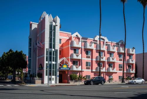 a large red building with cars parked in front of it at Days Inn by Wyndham Santa Monica/Los Angeles in Los Angeles
