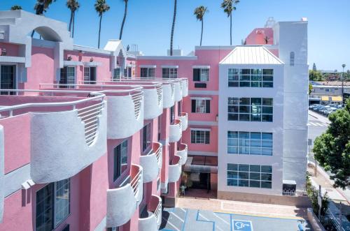an apartment building with white balconies and pink at Days Inn by Wyndham Santa Monica in Los Angeles