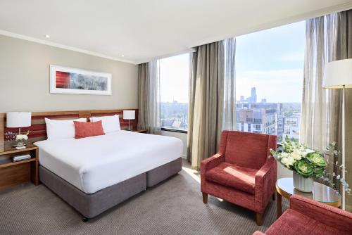 a hotel room with a bed and a chair at View Melbourne in Melbourne