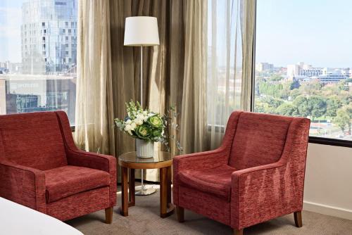 two chairs and a table in a room with a window at View Melbourne in Melbourne