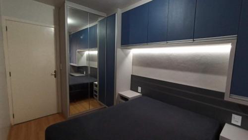 a small bedroom with blue cabinets and a bed at Sobrado completo em Caxias do Sul in Caxias do Sul