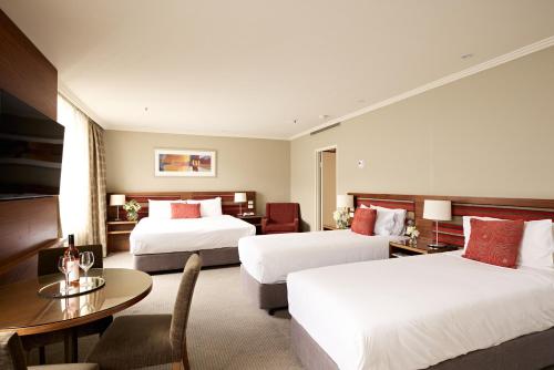 a hotel room with two beds and a table at View Melbourne in Melbourne