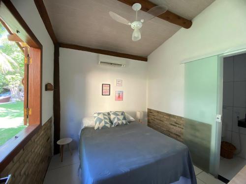 a bedroom with a bed and a ceiling fan at Maui Suítes e Chalés in Arraial d'Ajuda