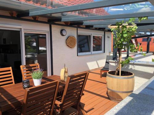 a wooden deck with chairs and a potted tree at Apartment Keuerleber in Holzmaden