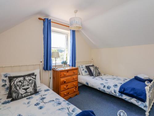 1 dormitorio con 2 camas y ventana en Cameron's Cottage en Swaffham