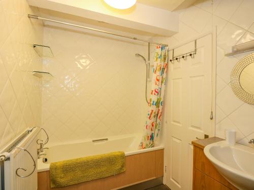 y baño con bañera, lavamanos y ducha. en Cameron's Cottage en Swaffham