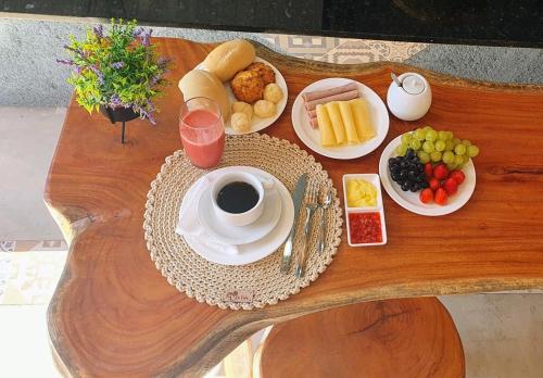 a table with breakfast foods and a cup of coffee at Pousada La Vita in São Miguel dos Milagres
