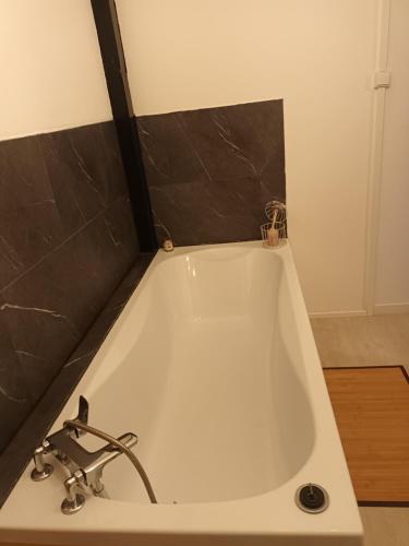 een wit bad met een kraan in de badkamer bij U San Francescu Maisonette Modulaire Type studio in Volpajola