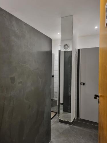 a bathroom with a metal wall and a door at Sao Paulo Hostel Club in São Paulo