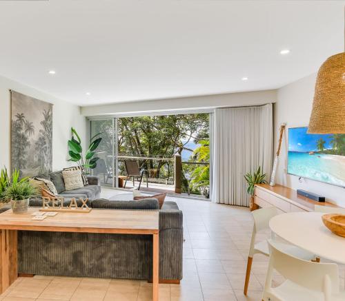 a living room with a couch and a table at Little Cove Court - Apartment 11 in Noosa Heads