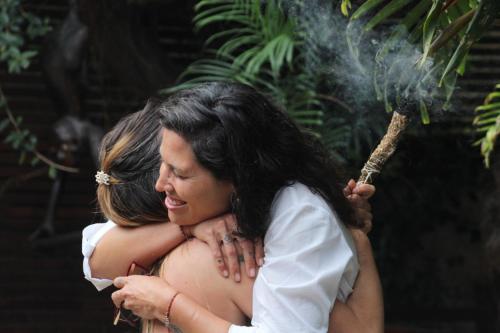 a pregnant woman is holding a smoke grenade at POUSADA ENCANTO DO AMOR in Búzios
