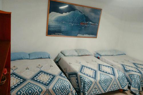 2 Betten in einem Zimmer mit einem Bild an der Wand in der Unterkunft México Lindo in Mexiko-Stadt