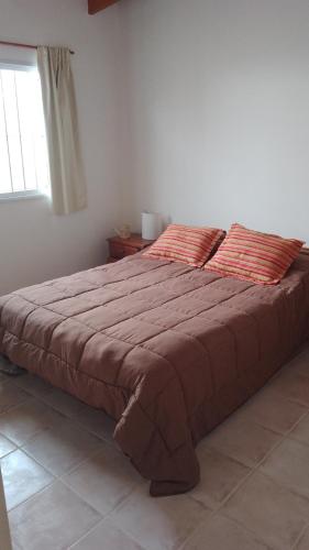 duże łóżko w sypialni z oknem w obiekcie Alquiler por día Choele Choel 3 w mieście Choele Choel