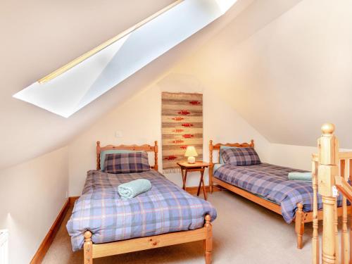 two beds in a attic bedroom with a skylight at The Old Laundry in Grantown on Spey