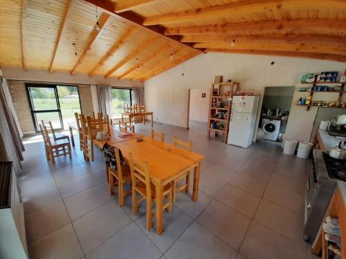a kitchen with a table and chairs and a refrigerator at PUERTO HOSTEL in El Hoyo