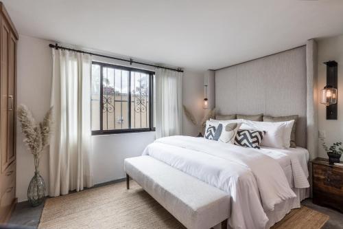 a white bedroom with a large bed and a window at Casa Recreo King Suite Apartments in Centro, San Miguel de Allende in San Miguel de Allende