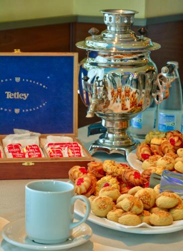 a table with a plate of pastries and a cup of coffee at Aqua Hotel in Burgas City