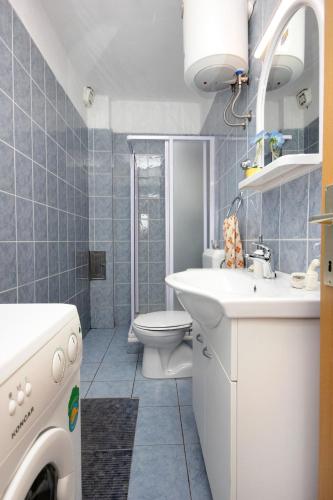 a bathroom with a toilet and a sink and a washing machine at Apartments with parking space Zaglav, Dugi otok - 878 in Zaglav