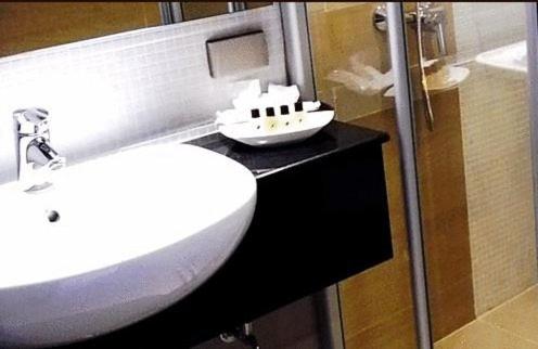 a bathroom with a white sink and a mirror at April Suites in Pattaya Central