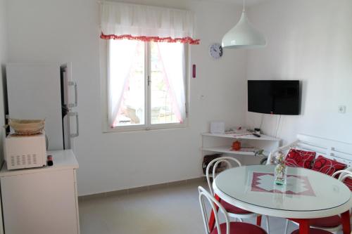 a kitchen with a table and chairs and a window at Apartments by the sea Mimice, Omis - 656 in Mimice