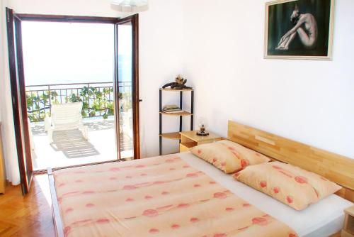 - une chambre avec un lit et une porte coulissante en verre dans l'établissement Apartments by the sea Pisak, Omis - 658, à Mimice