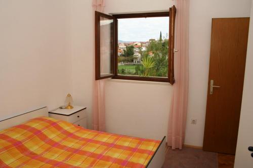 a small bedroom with a bed and a window at Apartments with a parking space Postira, Brac - 700 in Postira