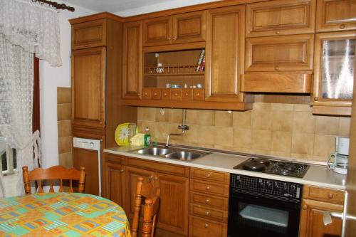 una cocina con armarios de madera y fregadero en Apartments with a parking space Postira, Brac - 700, en Postira