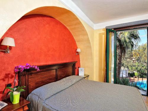 a bedroom with a bed and a red wall at Hotel Arbatasar in Àrbatax