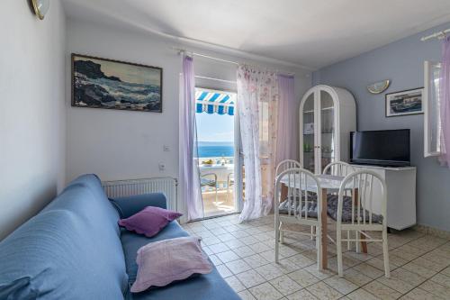 a living room with a blue couch and a table with chairs at Apartments by the sea Puntinak, Brac - 718 in Selca