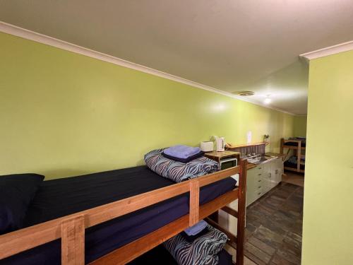 a bedroom with a bunk bed and a desk at Mingling Waters in Nowa Nowa