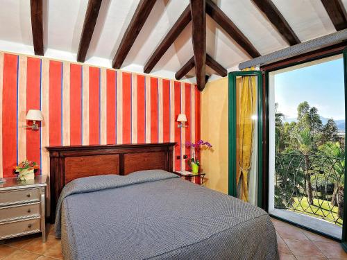 a bedroom with a bed and a large window at Hotel Arbatasar in Àrbatax