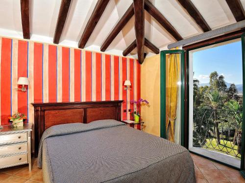 a bedroom with a bed and a large window at Hotel Arbatasar in Àrbatax