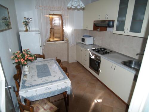 a small kitchen with a table and a sink at Apartments by the sea Sutivan, Brac - 719 in Sutivan