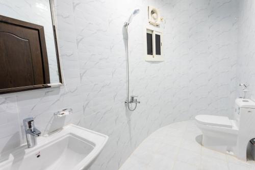 a white bathroom with a sink and a toilet at سوار للوحدات السكنية in Taif