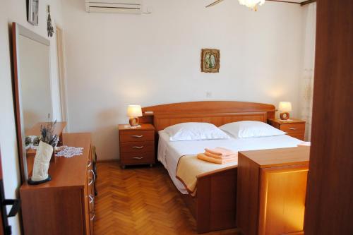 a bedroom with a bed with two night stands and two tables at Apartments by the sea Milna, Brac - 733 in Milna