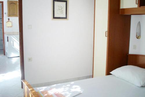 a bedroom with a white bed and a mirror at Apartments by the sea Milna, Brac - 735 in Milna