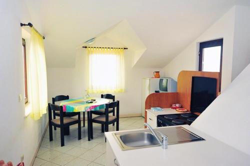 a kitchen with a sink and a table with chairs at Apartments by the sea Postira, Brac - 739 in Postira