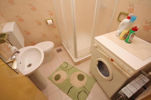 a bathroom with a toilet and a washing machine at Apartments by the sea Postira, Brac - 740 in Postira